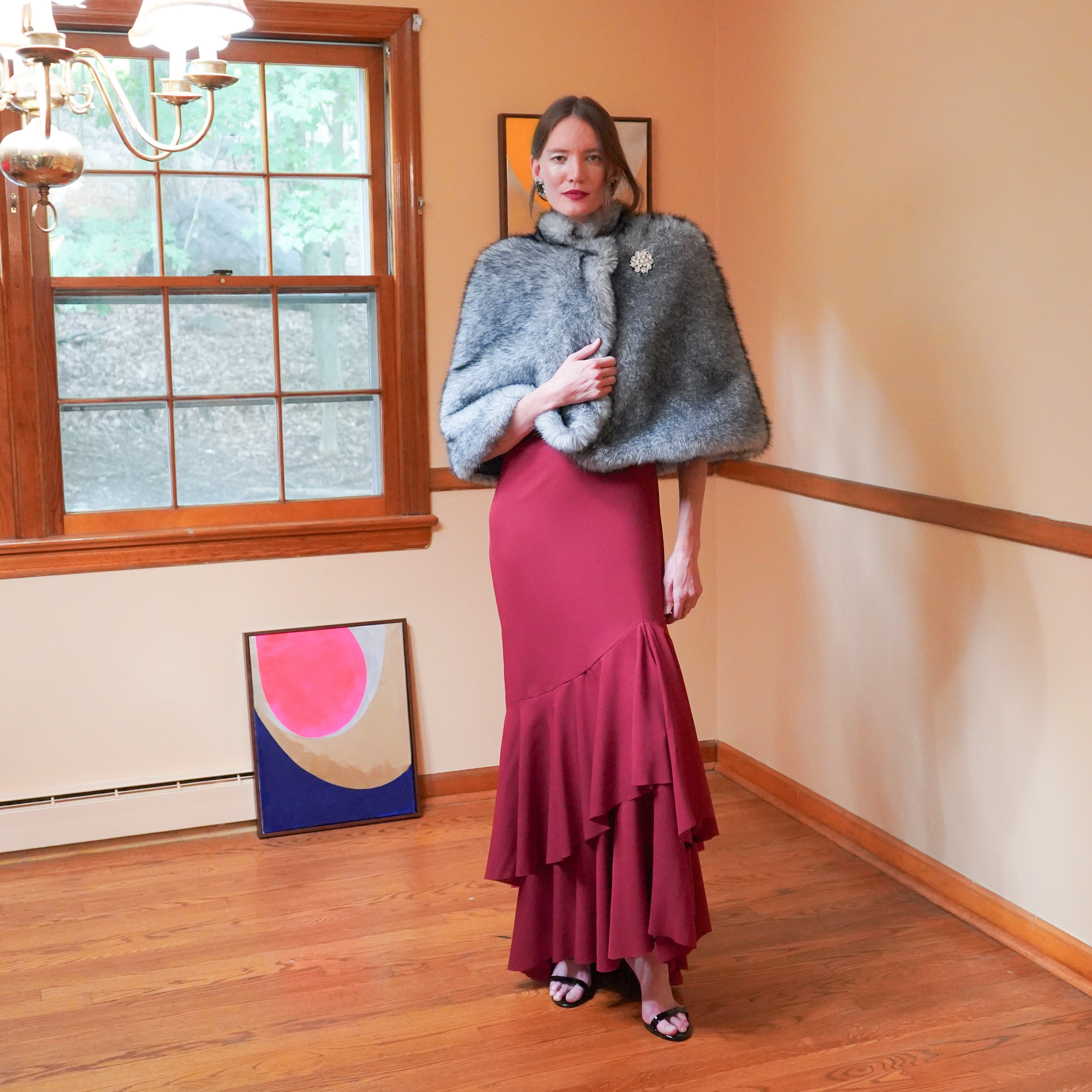 A gray faux fur Capelet with a Mandarin collar and front snap closure.