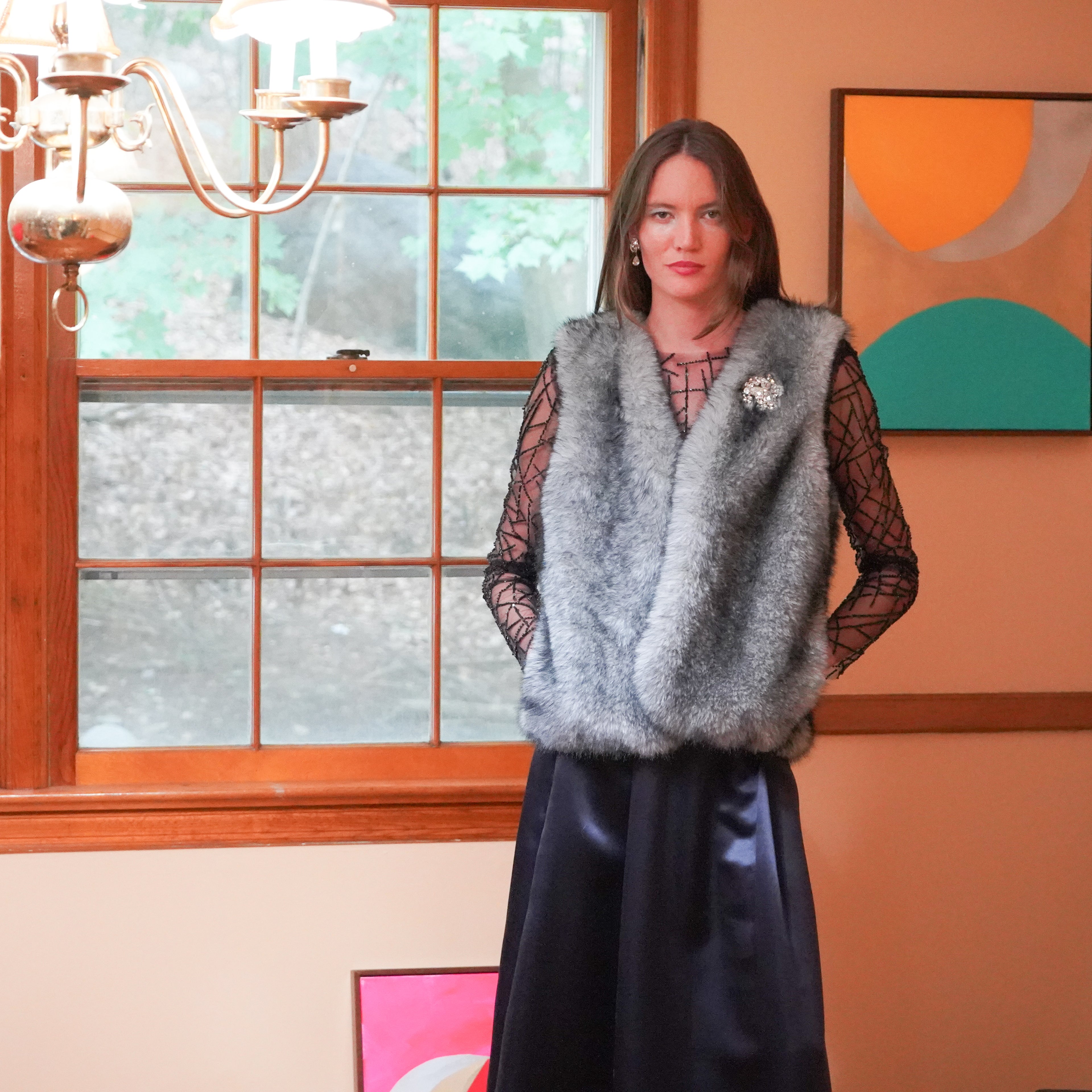 Gray faux-fur vest over a black mesh long-sleeve beaded top and a dark navy Charmeuse skirt. 